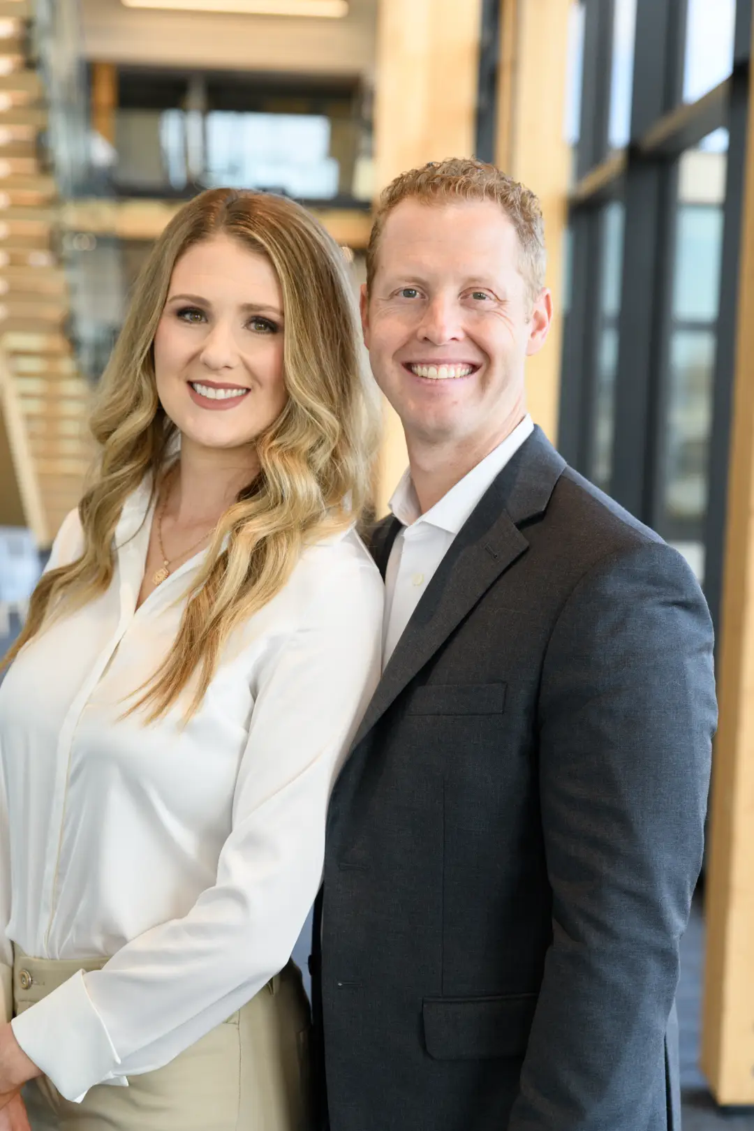 Two professionals in formal attire standing side by side.